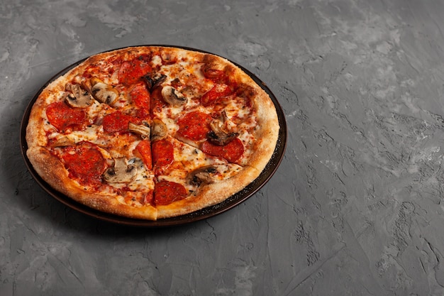 Leckere Pizza mit Salame und Pilzen mit Kopierraum. Draufsicht auf geschnittene Pizza.