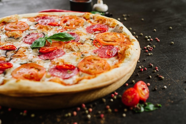 Leckere Pizza mit Salami und Käse auf schwarzem Hintergrund