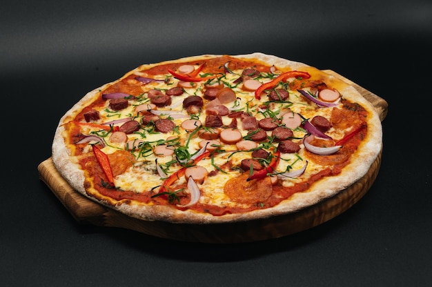 Leckere Pizza mit Salami und Speck auf einem Brett