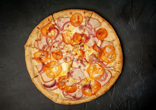 leckere Pizza mit Schinken, Tomate, Chili, Tomatensauce, Mozzarella auf Steinhintergrund