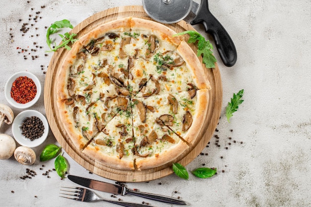 Leckere Pizza mit Schinkenpilzen und Zwiebeln auf Betonhintergrund