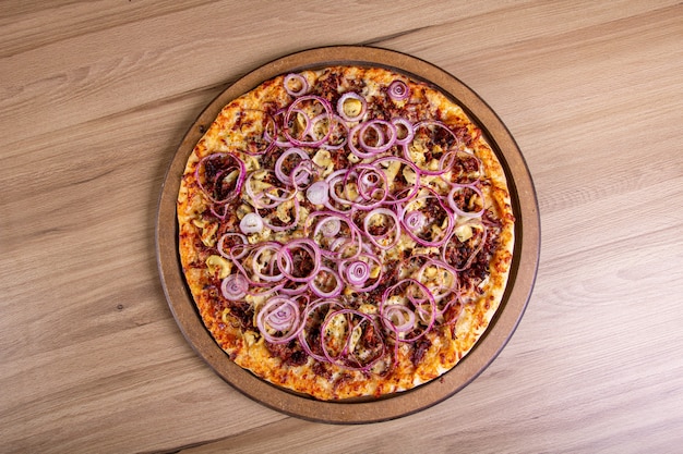 Leckere Pizza mit viel Füllung auf einem Holztisch