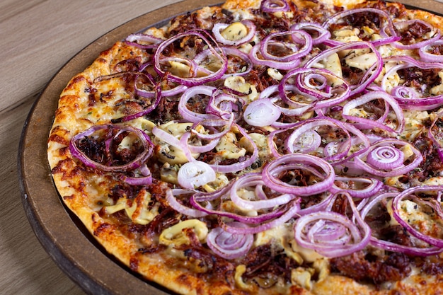 Leckere Pizza mit viel Füllung auf einem Holztisch