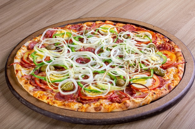 Leckere Pizza mit viel Füllung auf einem Holztisch