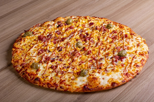 Leckere Pizza mit viel Füllung auf einem Holztisch