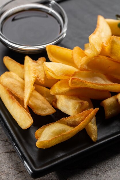 Leckere Pommes Frites auf Schneidebrett auf Holztischhintergrund Draufsicht flach gelegt