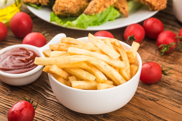 Leckere Pommes Frites auf Schneidebrett, auf Holztischoberfläche