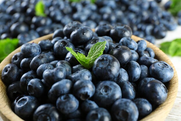 Leckere reife Heidelbeeren mit Minze in Schüssel auf dem Tisch hautnah