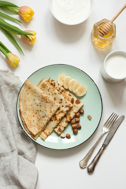 Leckere russische Frühstückspfannkuchen, Milch, Sauerrahm, Honig. Frühling. Fastnacht.