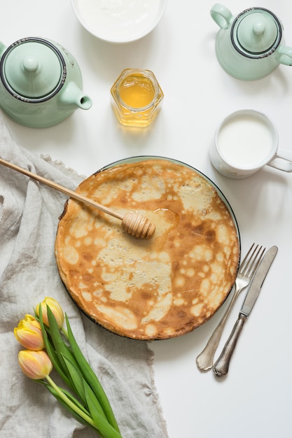 Leckere russische Frühstückspfannkuchen, Milch, Sauerrahm, Honig. Frühling. Fastnacht.