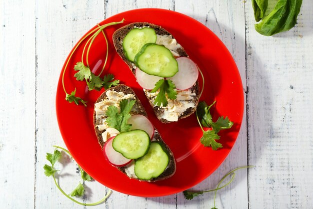 Leckere Sandwiches mit Gemüse und Gemüse auf dem Teller auf dem Tisch aus nächster Nähe