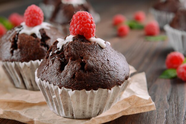 Leckere Schokoladen-Cupcakes mit Beeren auf dem Tisch aus nächster Nähe