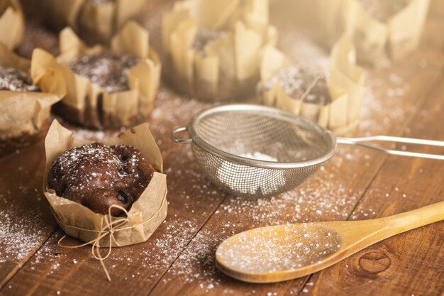 Leckere Schokoladenmuffins in Puderzucker auf dem Tisch