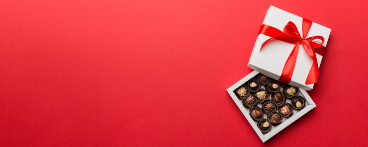 Foto leckere schokoladenpralinen in roter schachtel für valentinstag herzförmige schachtel mit schokoladen, top-view mit kopierplatz