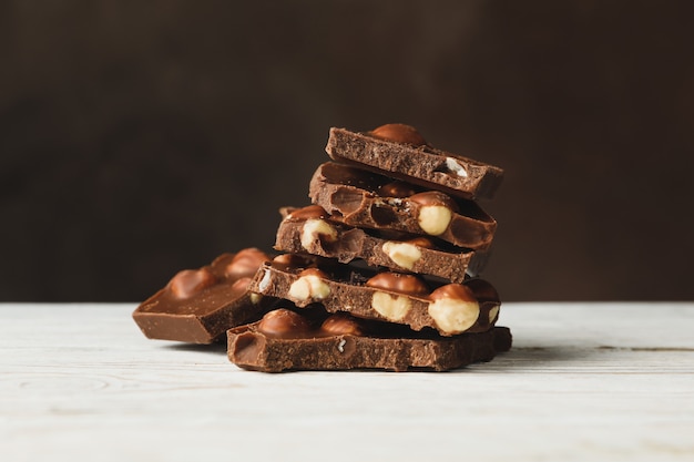 Leckere Schokoladenstücke auf weißem Holztisch