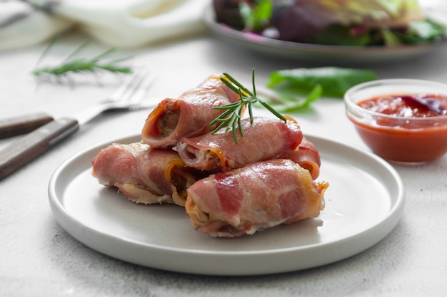 Leckere schweine in decken, in speck gewickeltes fleisch, hausgemachte gekochte fleischbissen. helles essensfoto.