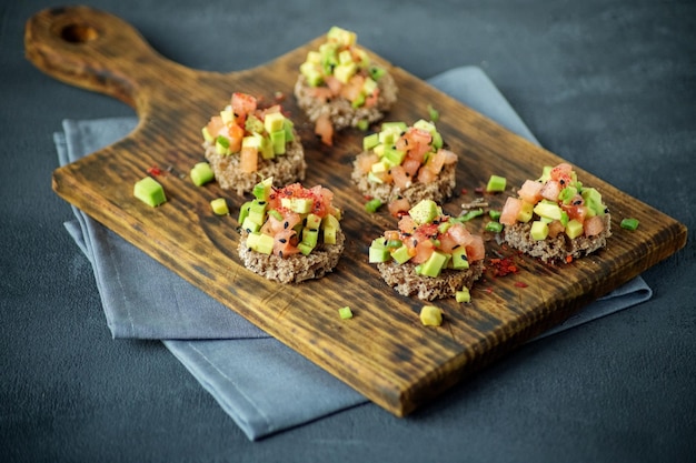 Leckere Snacks mit Brot, Avocado und Tomate Draufsicht Das Konzept des gesunden Vegetarismus