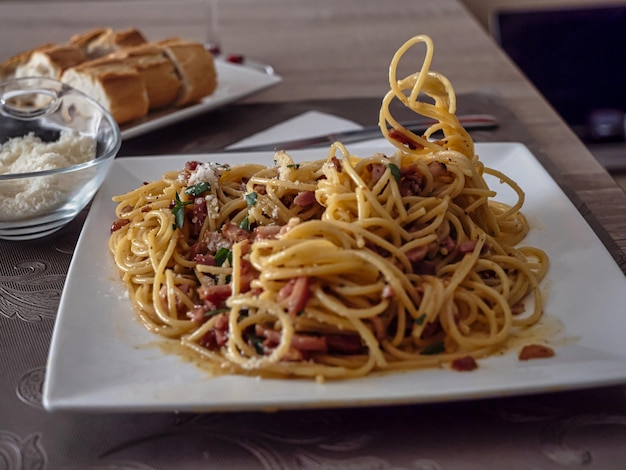 leckere Spaghetti Carbonara mit Brot und Käse