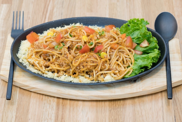 Leckere Spaghetti mit Hackfleisch und Gemüse mit Löffel und Gabel.