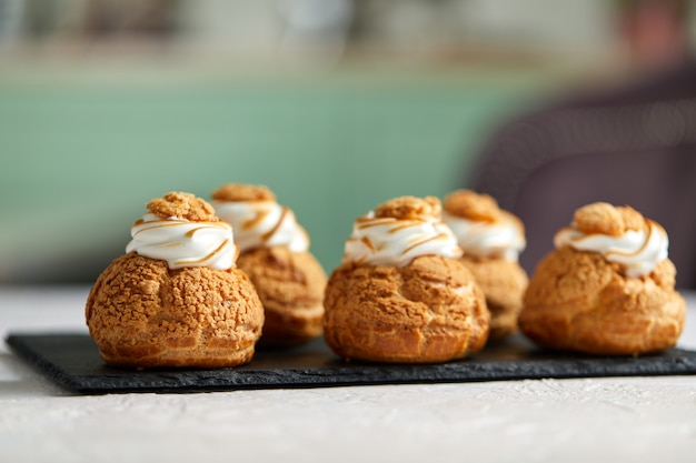 Leckere süße Cupcakes auf dem schwarzen Tablett