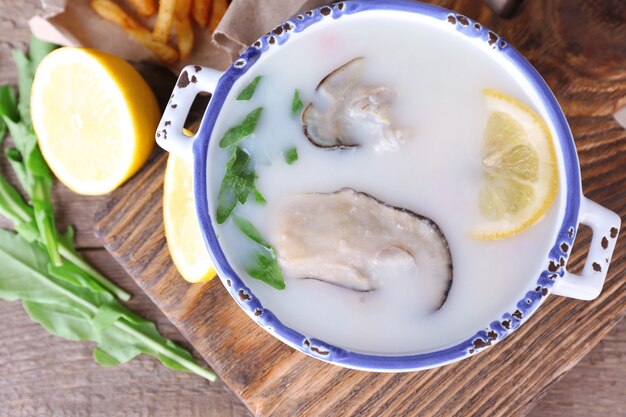 Leckere Suppe mit Austern auf Holztisch