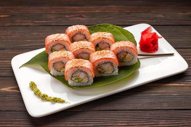 Leckere Sushi-Rollen mit Wasabi und Ingwer mit Essstäbchen