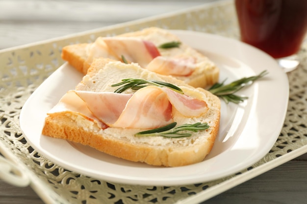 Leckere Toasts mit Speck und Kaffee zum Frühstück auf dem Tablett