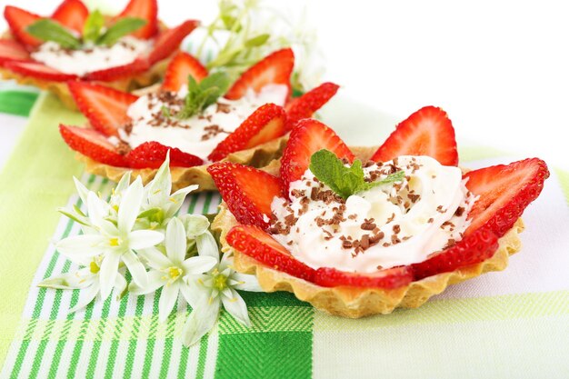 Leckere Törtchen mit Erdbeeren auf dem Tisch in der Nähe