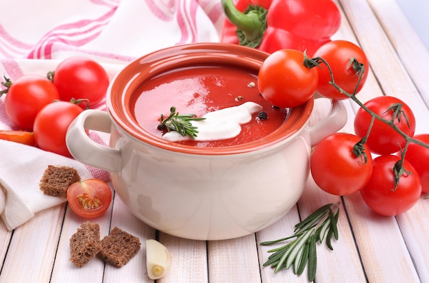 Leckere Tomatensuppe und Gemüse auf Holztisch