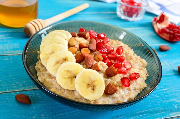 Leckere und gesunde Haferflocken mit Banane, Granatapfelkernen, Mandel und Zimt. Gesundes Frühstück. Fitness-Essen. Richtige Ernährung.