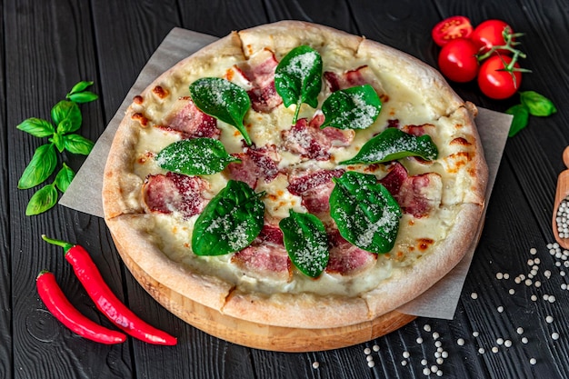 Leckere und große Pizza mit Speck und frischem Salat