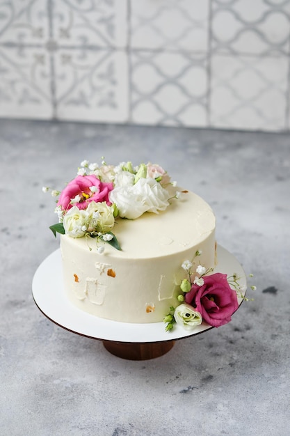 Leckere und schöne Hochzeitstorte. Die weiße Torte ist mit natürlichen Rosenblüten verziert.