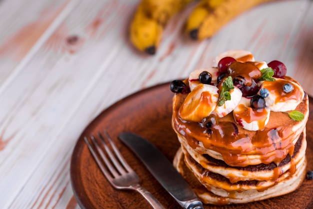 Leckere und üppige Pfannkuchen mit frischen Früchten und Beeren, gegossen mit gesalzenem Karamell.