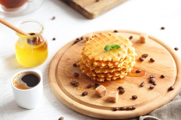 Leckere Waffeln mit Kaffee auf Schneidebrett