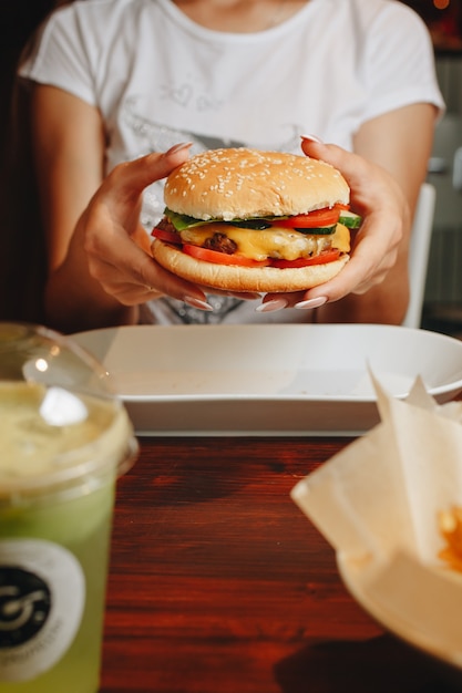 Leckerer Burger. stilvolle Hipsterfrau, die saftigen Hamburger hält