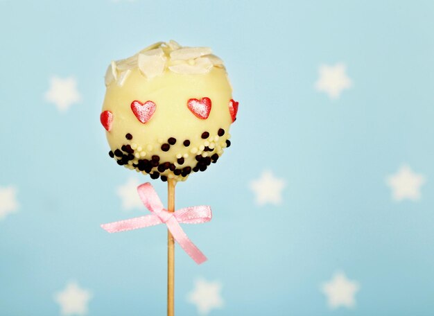 Leckerer Cake Pop auf blauem Hintergrund