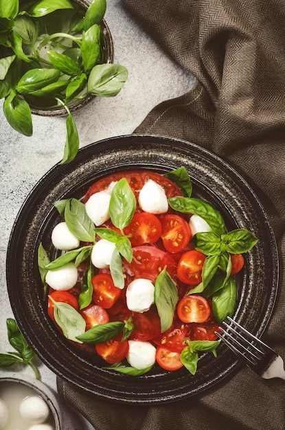 Leckerer Caprese-Salat mit reifen roten Tomaten und Mozzarella-Käse mit frischen grünen Basilikumblättern Italienische Küche Draufsicht