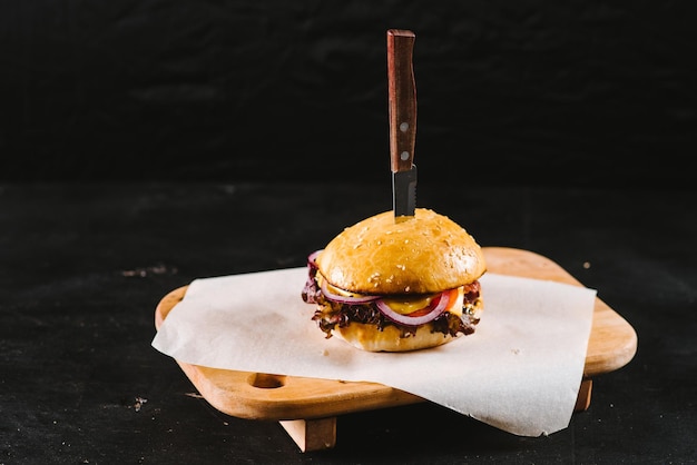 Leckerer Fast-Food-Burger auf schwarzem Hintergrund