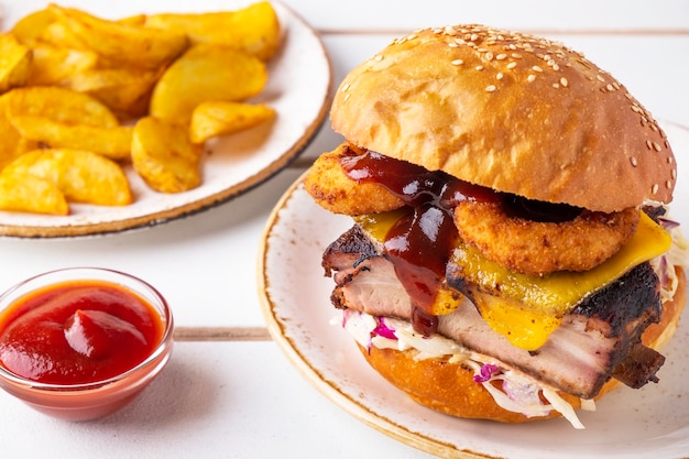 Leckerer Fleischburger mit Grillrippchen, Zwiebelringen, Käse, Kohl und Salat. Fleischburger garnieren mit Kartoffeln und Ketchup