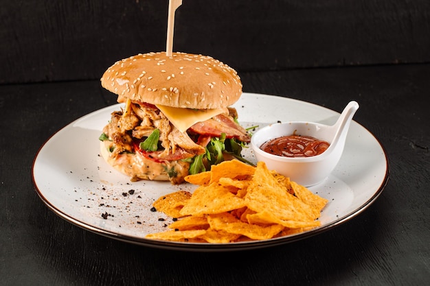 Leckerer frischer Burger mit eingekauftem Fleisch und Pommes auf Holzhintergrund