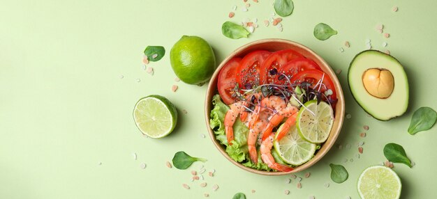 Leckerer Garnelensalat auf grünem Hintergrund, Ansicht von oben