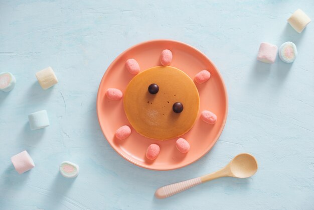 Leckerer gebratener Pfannkuchen mit schönem Gesicht isoliert, süßes Dessert