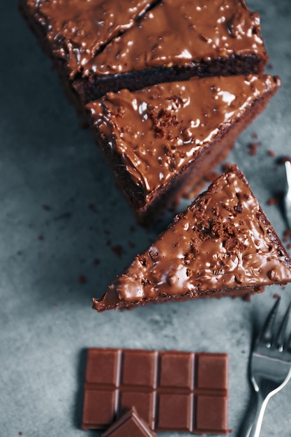 Leckerer geschnittener Kuchen mit Schokolade und Gabeln auf grauem Hintergrund hautnah