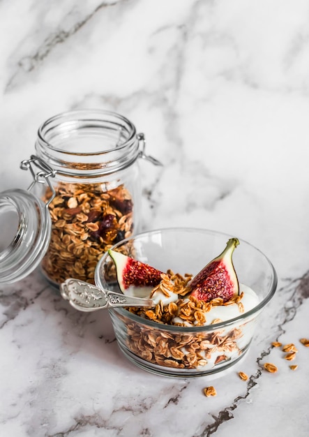 Foto leckerer, gesunder griechischer frühstücksjoghurt mit hausgemachtem müsli und feigen auf hellem hintergrund, draufsicht