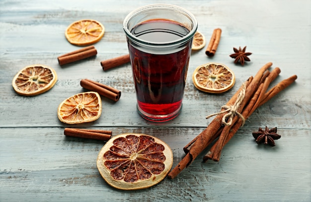 Leckerer Glühwein und Gewürze, auf blauem Holztisch, Nahaufnahme