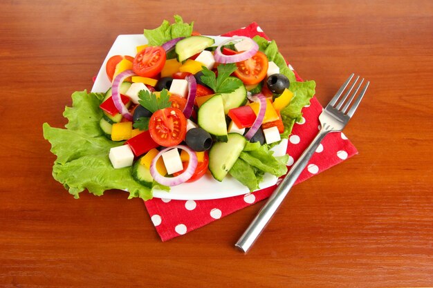 Leckerer griechischer Salat auf Holzhintergrund