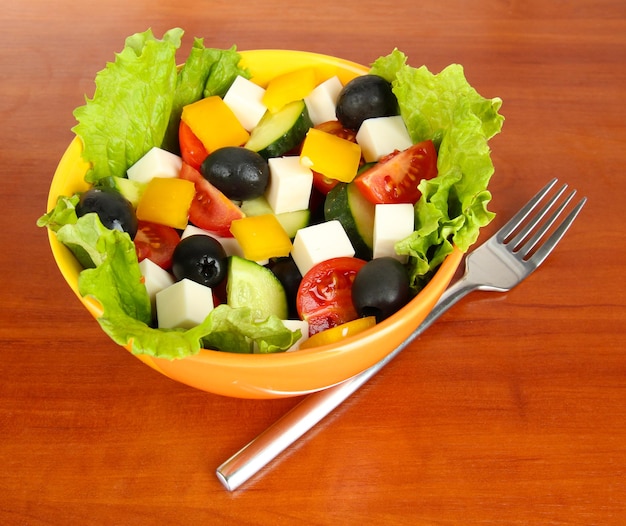 Leckerer griechischer Salat auf Holzhintergrund