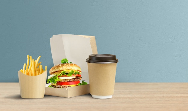 Leckerer Hamburger, Pommes und Kaffee in Kartonverpackungen zum Mitnehmen.