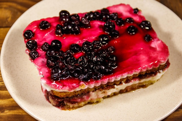 Leckerer Käsekuchen mit schwarzer Johannisbeere auf Holztisch