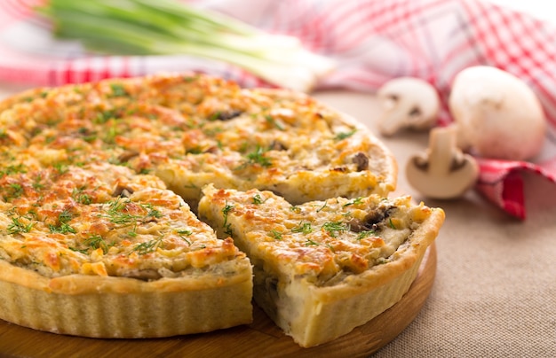 Leckerer Kuchen mit Hühnchen und Pilzen auf dem Tisch